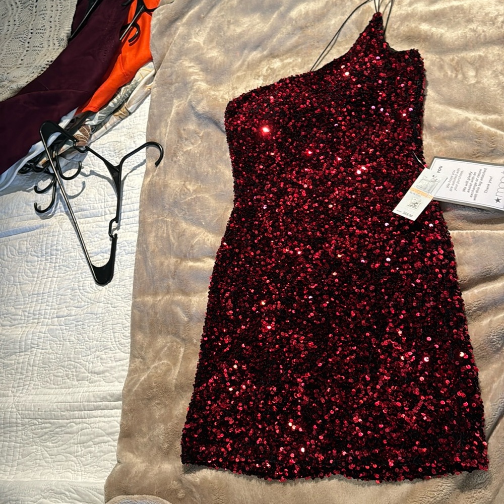 Dark red sequined dress with thin one sided black strap. New with tags.